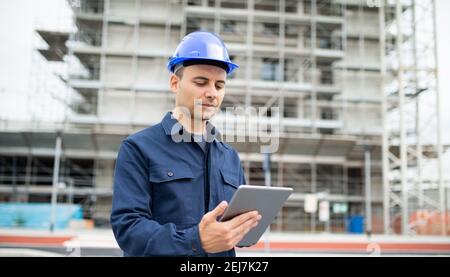 Young engineer man wearing an helmet working on tablet pc Stock Photo