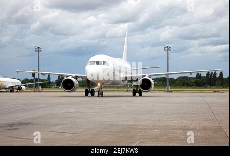 Passanger white plane lands. Blue airplane on the platform of Airport. Runway. Landing aircraft. Stock Photo