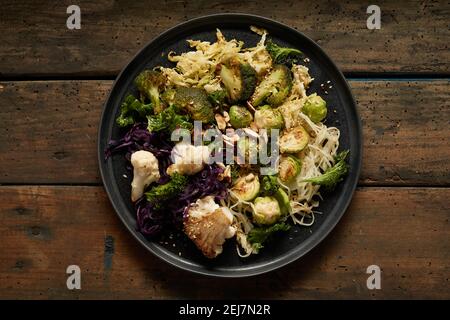From above of delicious noodles and various grilled cabbages served in plate on wooden table Stock Photo