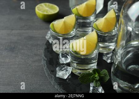 Concept of party drink with shots of vodka on black tray Stock Photo