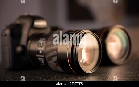 Professional digital camera close-up on a blurred background. The concept of technology for working with photos and videos. Stock Photo