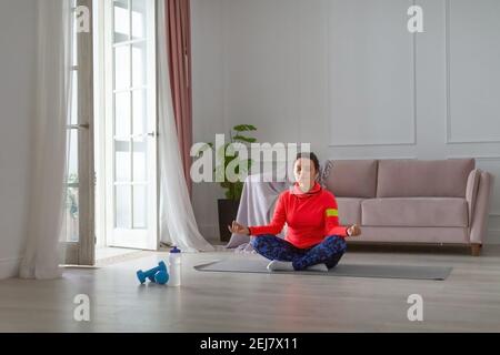 Middle-aged woman meditates sitting in the lotus position. Healthy ...