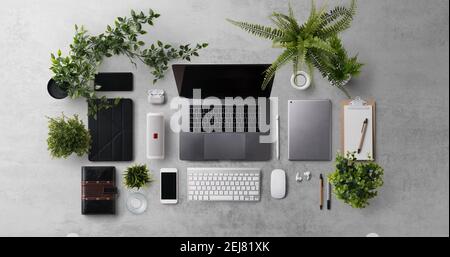Flat lay top view office desk working space with laptop and office supplies on dark background. Stock Photo