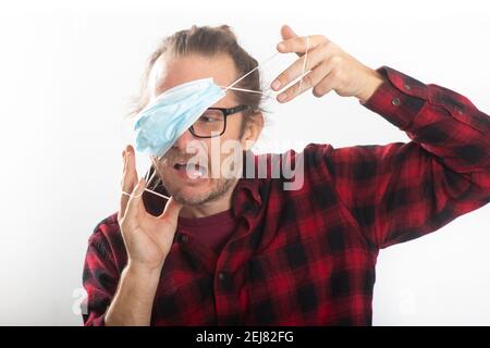 Portrait of man having trouble wearing a protective mask Stock Photo