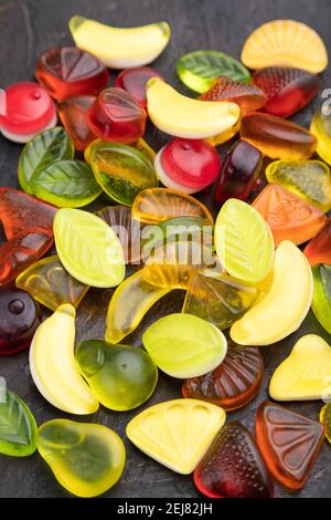Various fruit jelly candies on black concrete background. side view, close up. Stock Photo