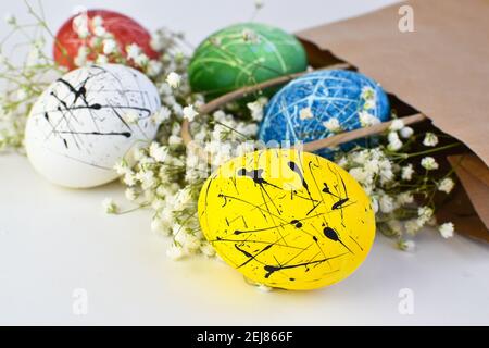 Close-up of a yellow egg with a black spot on the background of eggs in a paper bag. Delivery on Easter. Stock Photo
