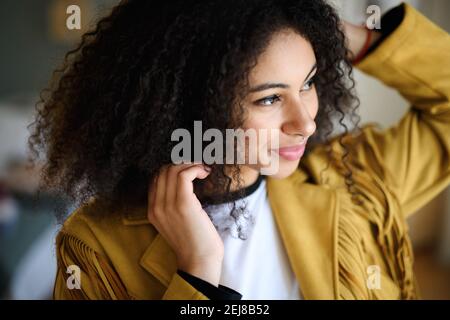 Close-up portrait of beautiful young woman indoors, standing. Stock Photo