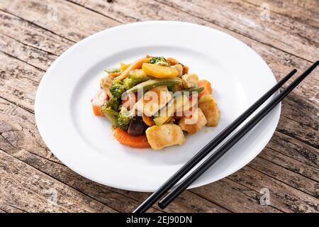 Stir fry chicken with vegetables on rustic wooden table Stock Photo