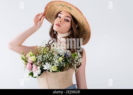 Fashionable model posing with flowers in blouse isolated on grey Stock Photo