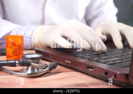 close up of doctor hand in latex gloves typing on laptop  Stock Photo