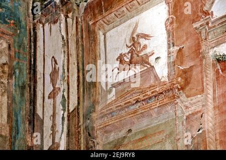 Interior of typical roman house in Herculaneum (Ercolano) archeological park. Close up view of a red painted wall