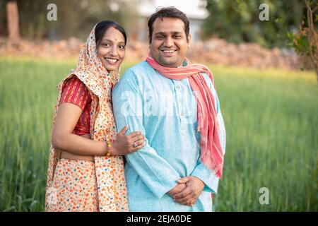Happy indian rural farmer couple in agricultural field. Stock Photo