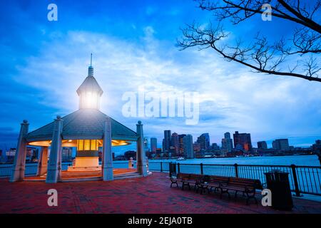 East Boston Piers Park Gazebo with lighthouse light in the evening over downtown panorama Stock Photo