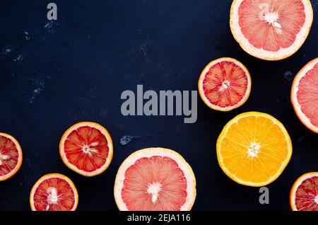 Halves of citrus on a blue backdrop. Top view. Stock Photo