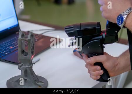 Man holding handheld 3d scanner for capturing object at 3d exhibition - close up Stock Photo