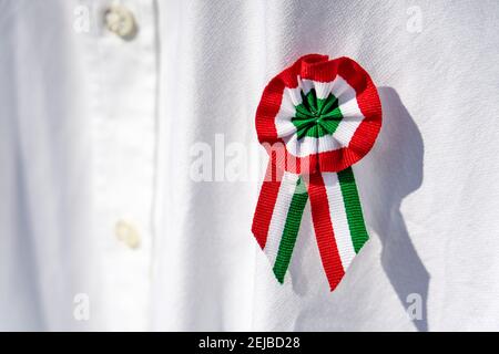 close up white shirt with tricolor rosette symbol of the hungarian national day 15th of march . Stock Photo