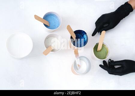 The process of creating a painting using fluid art technique. Hands with gloves and. Artistic background. Stock Photo