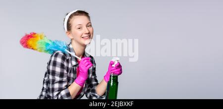 Banner- long format. Cleaning service concept, blonde girl wearing pink rubber gloves and cleaning tools - a spray bottle and dusting brush. Job Stock Photo