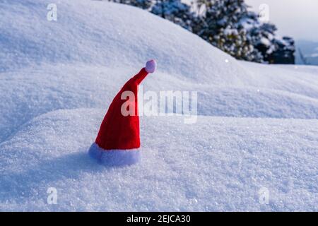 A small red christmas cap placed on snow. Stock Photo