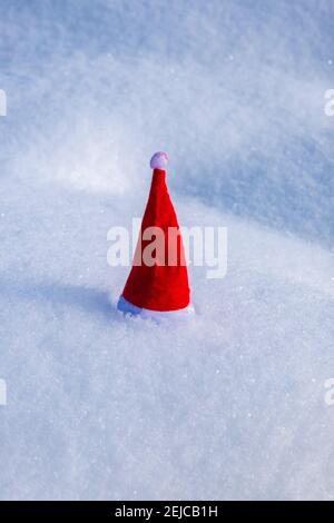 A small red christmas cap placed on snow. Stock Photo