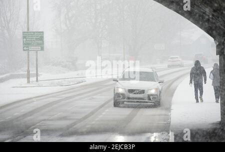 Cars driving on a snow covered road on a winter's day in Market Harborough, Leicestershire, United Kingdom. Stock Photo