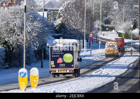 Vans driving on a snow covered road on a winter's day in Market Harborough, Leicestershire, United Kingdom. Stock Photo