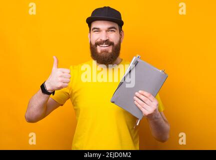 Good management, manage your time with planner, man showing thumb up and holding agenda. Stock Photo