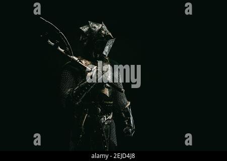 Portrait of a medieval fighter in armor, in profile, an ax on his shoulder Stock Photo
