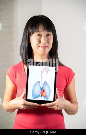 Woman holding screen with drawing of heart and lungs Stock Photo
