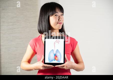 Woman holding screen with drawing of heart and lungs Stock Photo