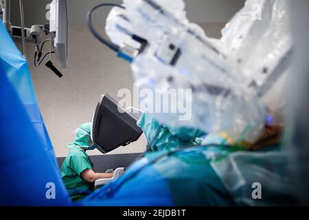 In the operating room, a hysterectomy with a surgical robot controlled from a console. Stock Photo