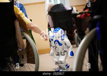 Humanoid robot speaking, singing, dancing and moving to meet residents of a nursing home. Stock Photo