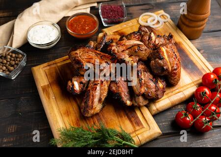 Grilled sliced barbecue pork ribs on a dark wooden background. Stock Photo