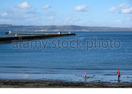 Edinburgh, Scotland, UK. 22th Feb 2021. People enjoying Granton harbour and breakwater looking from Wardie Bay on a cold and sunny afternoon.  Credit: Craig Brown/Alamy Live News Stock Photo