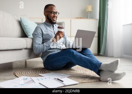 Happy African Freelancer Man Using Laptop Working From Home Stock Photo