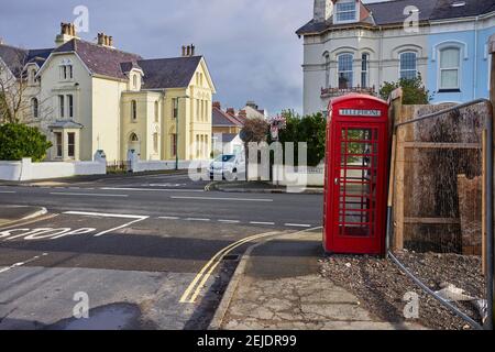 Red K6 style phone box at May Hill in Ramsey on the TT course next to the White Gates bend sign Stock Photo