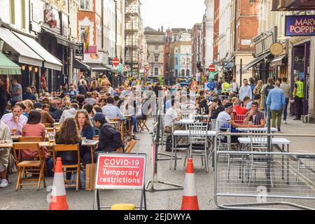 People in restaurants and bars in Old Compton Street, Soho. The temporary al fresco street seating was implemented to facilitate social distancing during the coronavirus pandemic. London, United Kingdom August 2020. Stock Photo