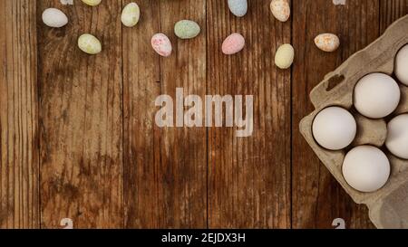 Chicken eggs in a cardboard tray and Easter decor on a wooden background., Rural Style. Frame with place for text Stock Photo