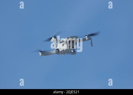 Small camera drone hovering in blue sky Stock Photo