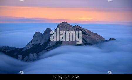 Blue hour at twilight in Montserrat with fog looking to the spires of Gorres and Magdalenes seen from the Sant Jeroni summit (Barcelona, Cataluña) Stock Photo