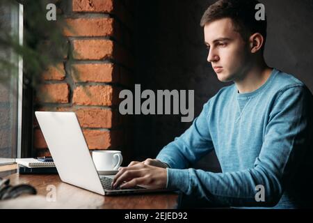 Business man with laptop in a cafe Sits opposite the window Stock Photo