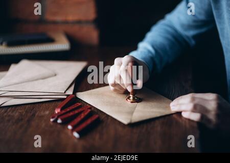 Man makes the stamp using sealing wax on the envelope Stock Photo