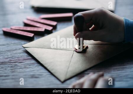 Man makes the stamp using sealing wax on the envelope Stock Photo