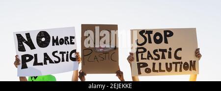 Group demonstrators protesting against plastic pollution and climate change - Multiracial people fighting on road holding banners Stock Photo