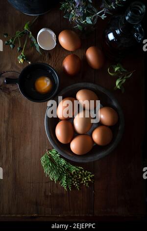 Fresh uncooked eggs in rustic bowl on natural wooden background. Raw chicken eggs on the wooden background. Stock Photo