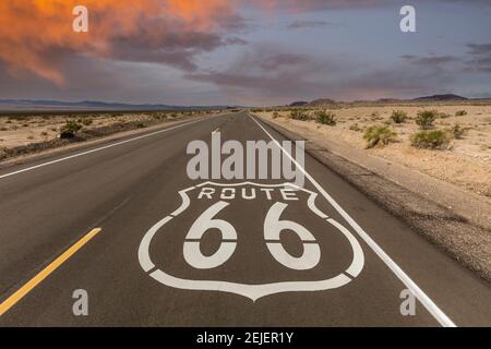Historic Route 66 pavement sign with sunset sky near Amboy in the California Mojave desert. Stock Photo