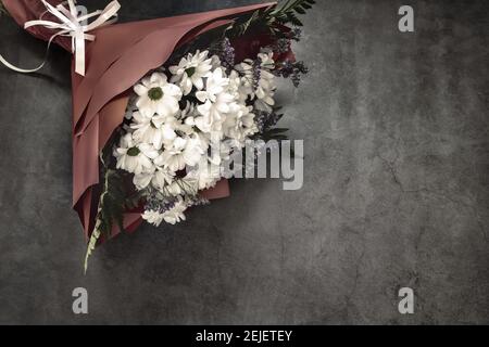 A beautifully designed bouquet of white chrysanthemums and red roses on a dark background. Top view, copy space Stock Photo