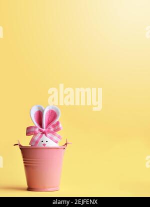 Easter holiday concept with cute handmade egg, bucket and bunny ears. Easter holiday decoration. Stock Photo