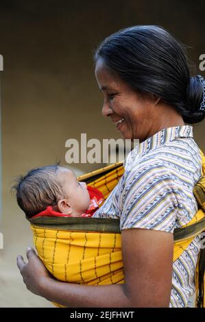 BANGLADESH, Region Madhupur, Garo people, matrilineal society, christian woman, grandmother with child / BANGLADESCH, Madhupur, Garos sind eine christliche u. ethnische Minderheit , Garo folgen einer matrilinearen Abstammungsregel, Garo Frau Kalpona Ritchil mit Enkel im Dorf Idilpur Stock Photo