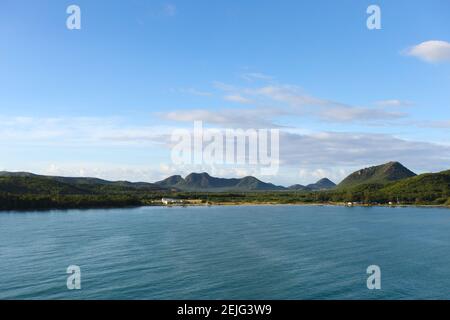 Distant view of the Eastern coastline of Antigua and distant Mountain range viewed from the Caribbean Sea. Stock Photo